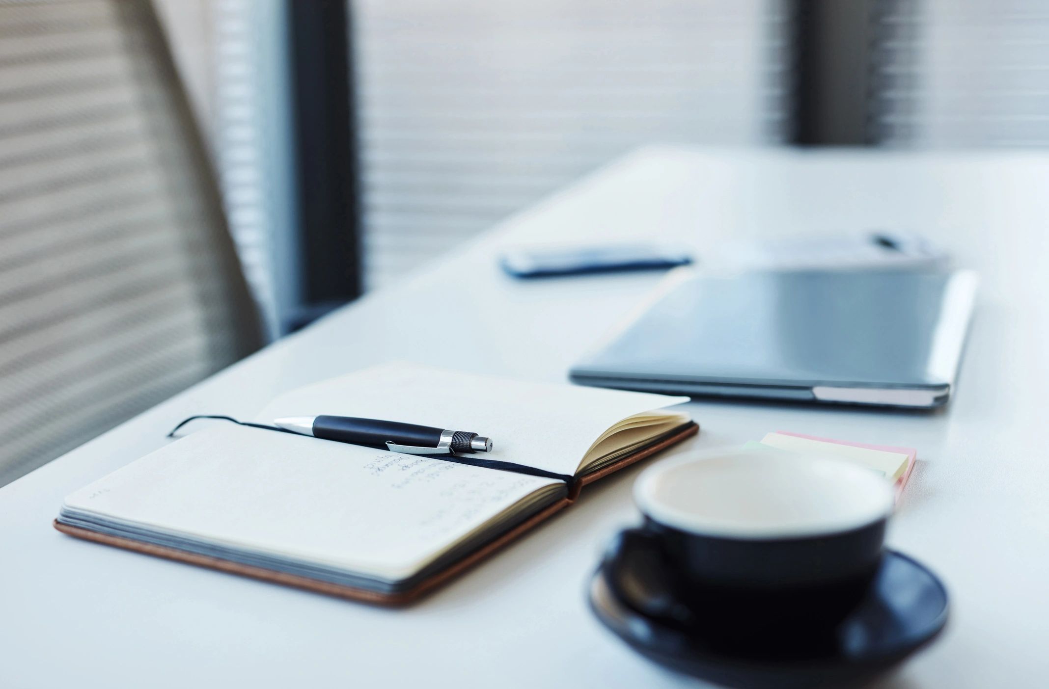 Notebook and laptop on a desk representing recordkeeping and communications