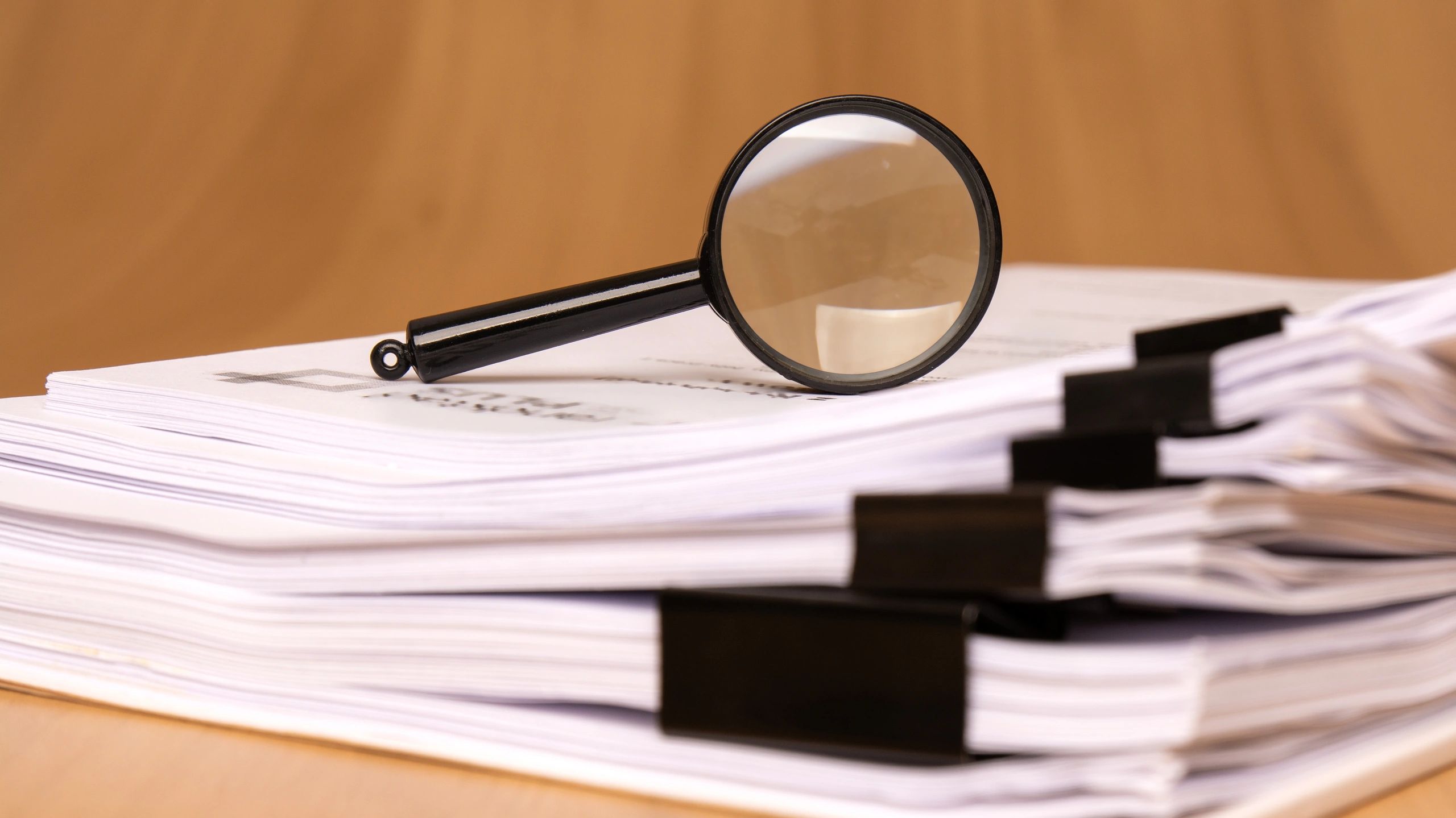 Magnifying glass over clipped papers
